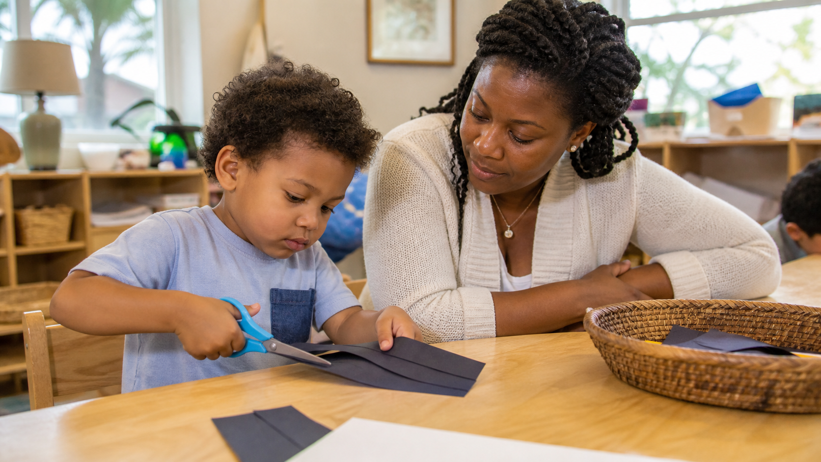 Preschool child using safety scissors with close teacher supervision